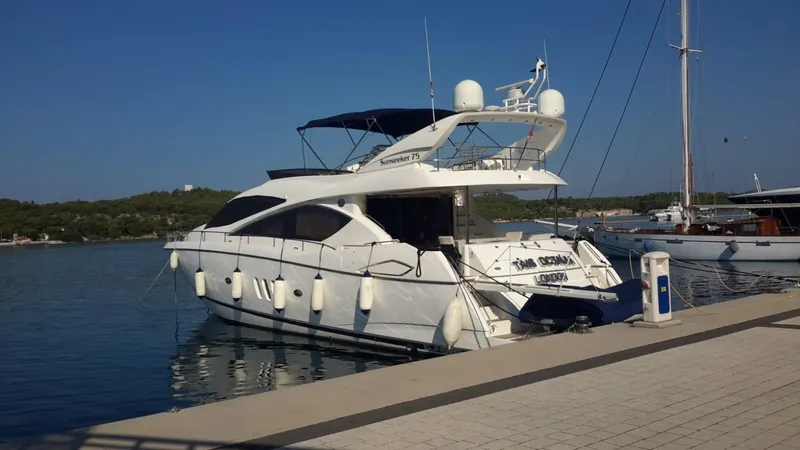 Tais Octavia Yacht Photos Pics 2005 Sunseeker 75 yacht docked at a marina, under clear blue skies.