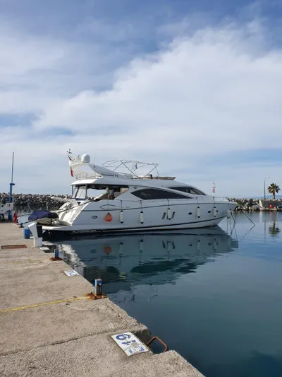 Tais Octavia Yacht Photos Pics 2005 Sunseeker 75 yacht docked at a marina under a partly cloudy sky.