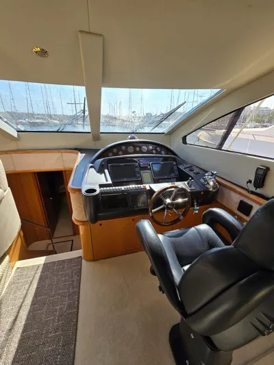 Tais Octavia Yacht Photos Pics Interior view of a 2005 Sunseeker 75 yacht cockpit with steering wheel and navigation equipment.