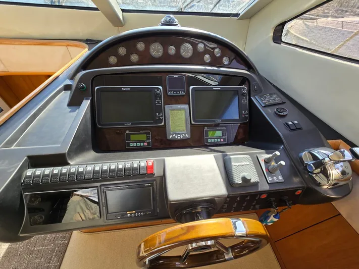 Tais Octavia Yacht Photos Pics Control panel of a 2005 Sunseeker 75 yacht with navigation instruments and steering wheel.