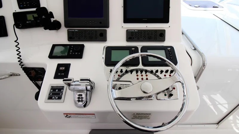 Feeva Yacht Photos Pics Control panel of a 2007 Cabo 40 Hardtop Express boat with steering wheel and navigation instruments.