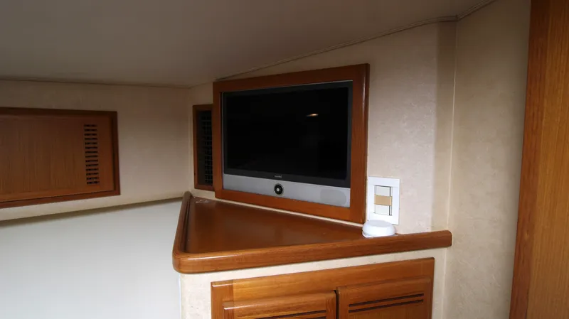 Feeva Yacht Photos Pics 2007 Cabo 40 Hardtop Express interior with mounted TV and wooden cabinetry.