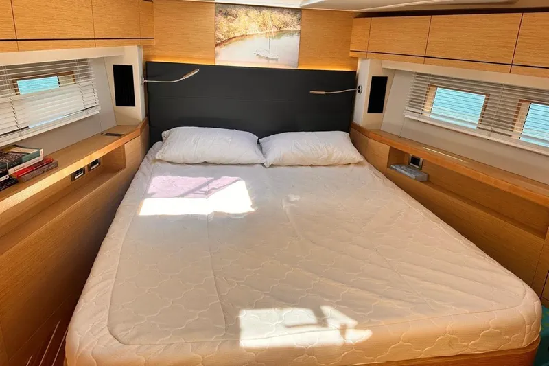  Yacht Photos Pics Luxurious cabin interior of 2018 Hanse 548 yacht with cozy bed and wooden accents.