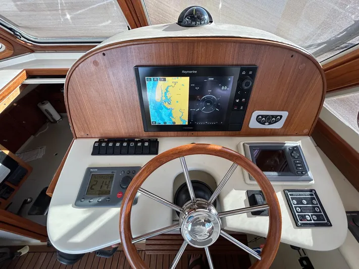 Freedom Yacht Photos Pics Helm of 2008 Legacy 32 boat with navigation equipment and wooden steering wheel.