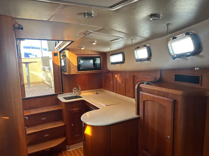 Freedom Yacht Photos Pics Luxurious 2008 Legacy 32 yacht interior with wooden cabinetry and modern kitchen amenities.