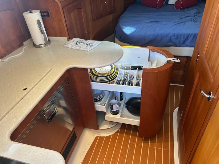 Freedom Yacht Photos Pics Compact kitchen area in a 2008 Legacy 32 boat with organized storage and cozy sleeping space.