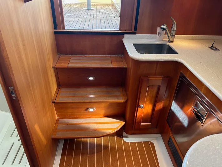 Freedom Yacht Photos Pics Interior of 2008 Legacy 32 yacht with wooden stairs and compact kitchenette.