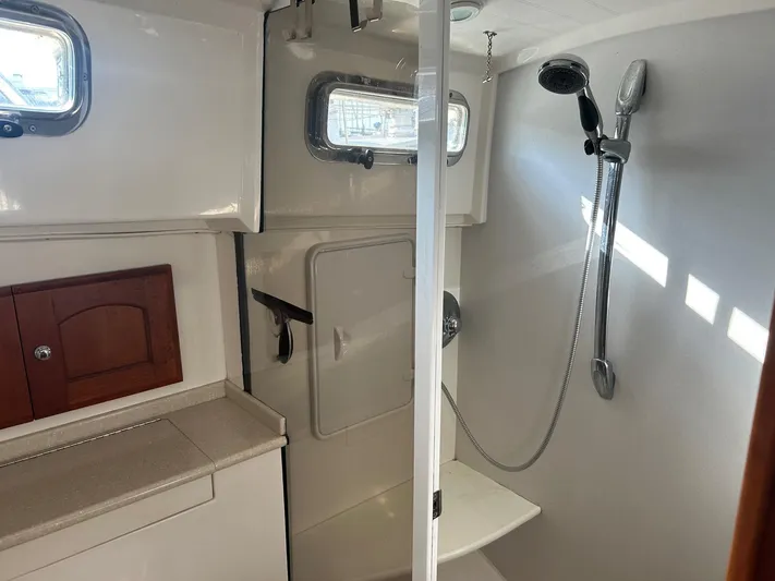 Freedom Yacht Photos Pics Interior of 2008 Legacy 32 boat bathroom with shower and wooden cabinet.