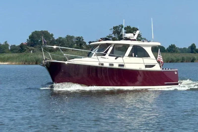 Freedom Yacht Photos Pics 2008 Legacy 32 boat cruising on a calm river with lush greenery in the background.