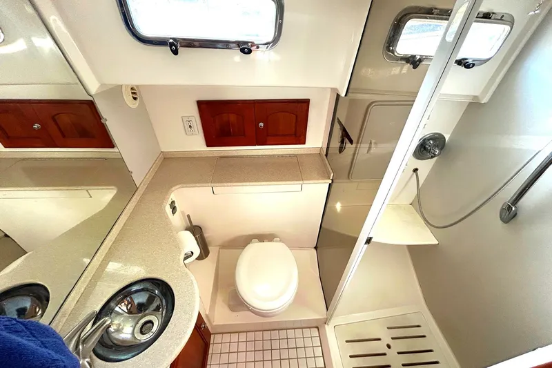 Freedom Yacht Photos Pics Compact 2008 Legacy 32 boat bathroom with shower, sink, and storage cabinets.