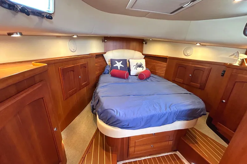 Freedom Yacht Photos Pics Luxurious cabin interior of 2008 Legacy 32 yacht with cozy bed and wooden furnishings.