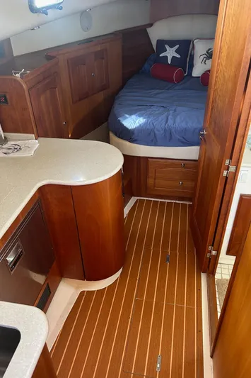 Freedom Yacht Photos Pics Luxurious 2008 Legacy 32 yacht interior with wood finish and cozy sleeping area.