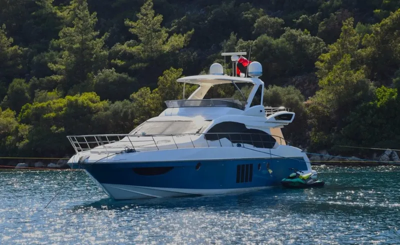 Yacht Photos Pics Luxurious 2010 Azimut 64 yacht anchored in scenic waters with lush greenery.