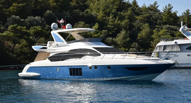  Yacht Photos Pics Luxury 2010 Azimut 64 yacht anchored in scenic waters, surrounded by lush greenery.