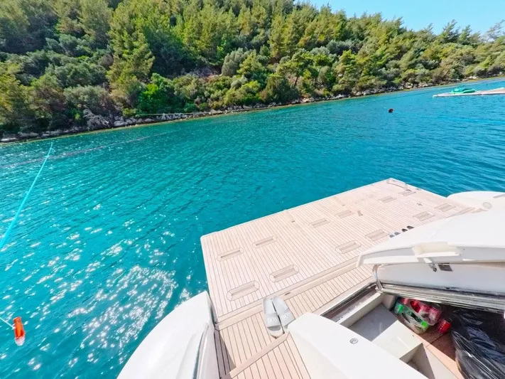  Yacht Photos Pics Azimut 64 yacht on clear blue water near lush green shoreline, 2010 model.