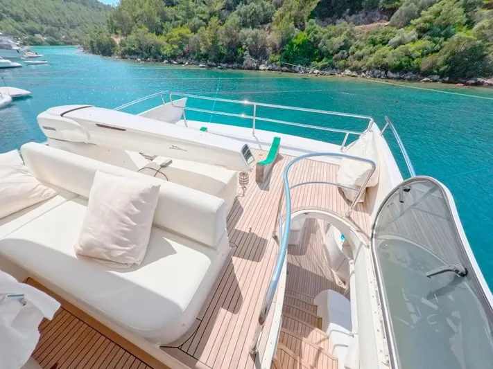  Yacht Photos Pics Luxurious 2010 Azimut 64 yacht deck with white seating, overlooking turquoise waters and lush greenery.