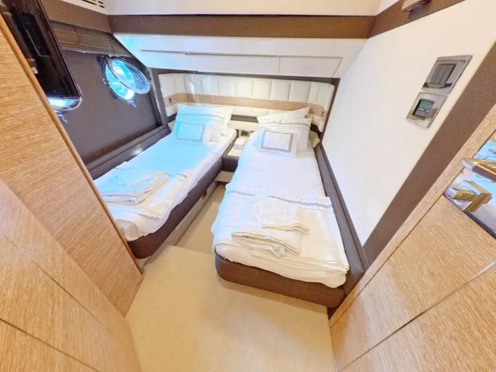  Yacht Photos Pics Luxurious twin cabin interior of 2010 Azimut 64 yacht with elegant bedding and porthole window.