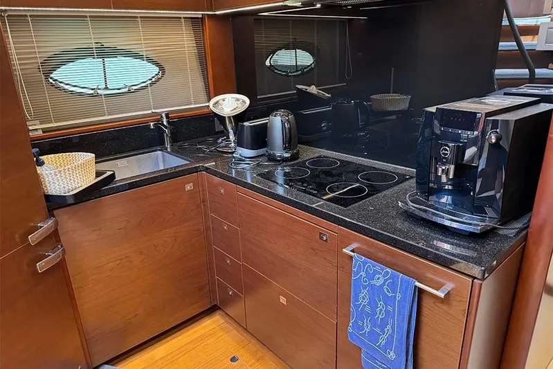  Yacht Photos Pics Luxurious kitchen interior of 2016 Princess S72 yacht with modern appliances and wooden cabinetry.