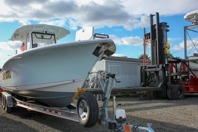  Yacht Photos Pics 2018 Sea Hunt Gamefish 30 boat on trailer, parked near forklift under blue sky.