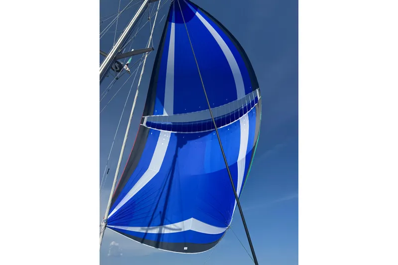  Yacht Photos Pics Blue and white sail on 2022 Lagoon 46 catamaran against clear sky.