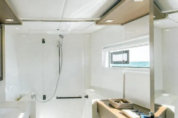  Yacht Photos Pics Modern bathroom interior in 2022 Lagoon 46 yacht with shower and window view.