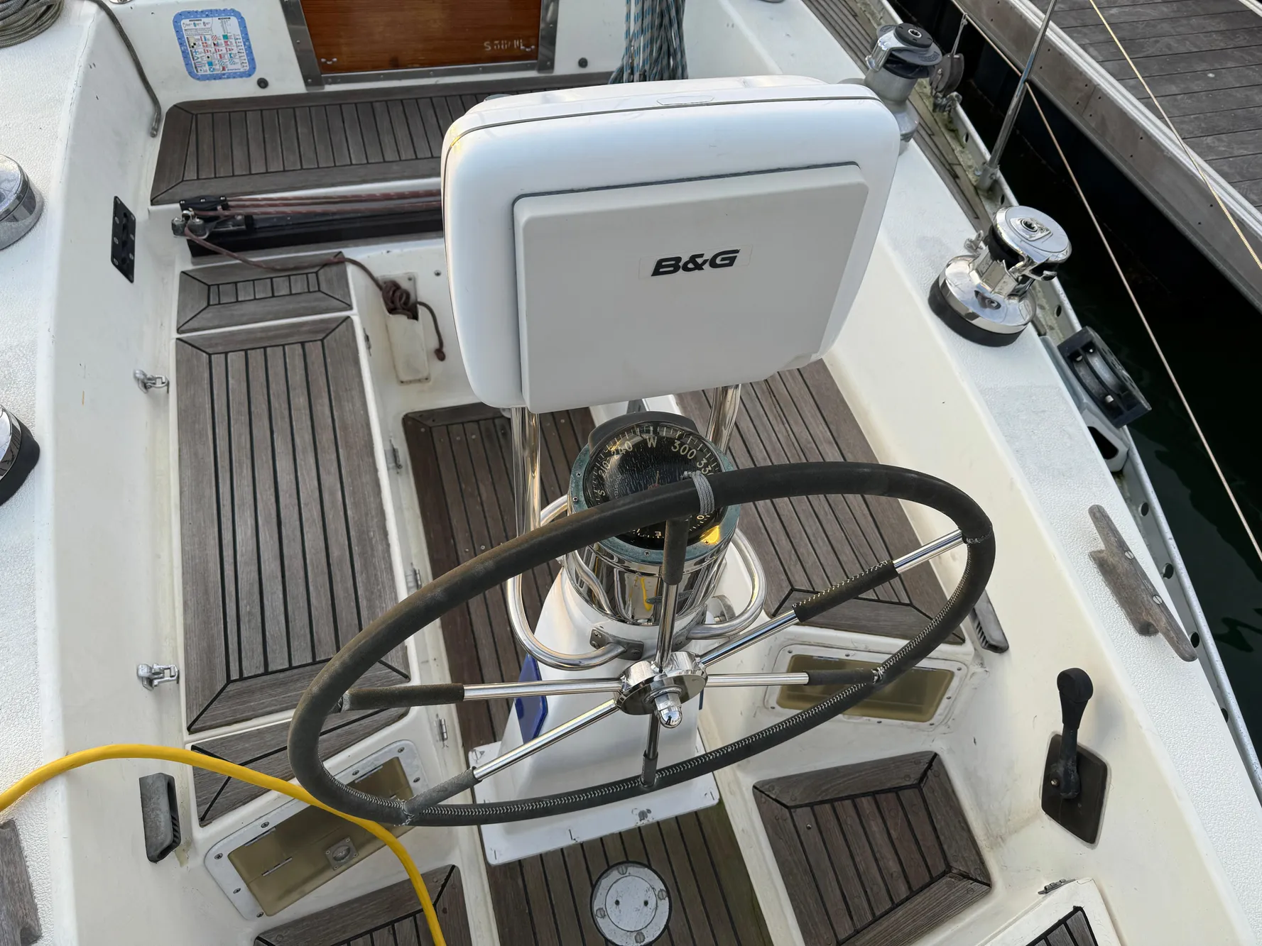Cockpit of 1974 Nautor Swan 38 sailboat with steering wheel and B&G navigation system.