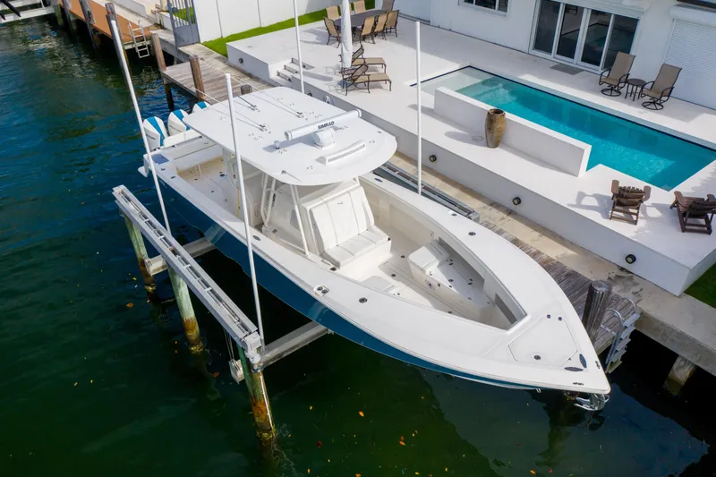 Seavee Yacht Photos Pics 2023 SeaVee 370z boat docked by a modern waterfront home with pool.