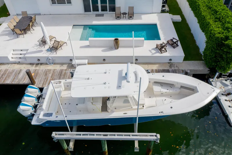 Seavee Yacht Photos Pics 2023 SeaVee 370z boat docked near a modern waterfront home with a pool.