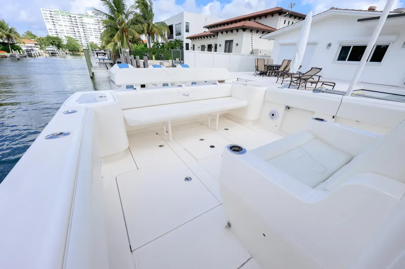 Seavee Yacht Photos Pics 2023 SeaVee 370z boat with spacious white deck and seating, docked by waterfront homes.