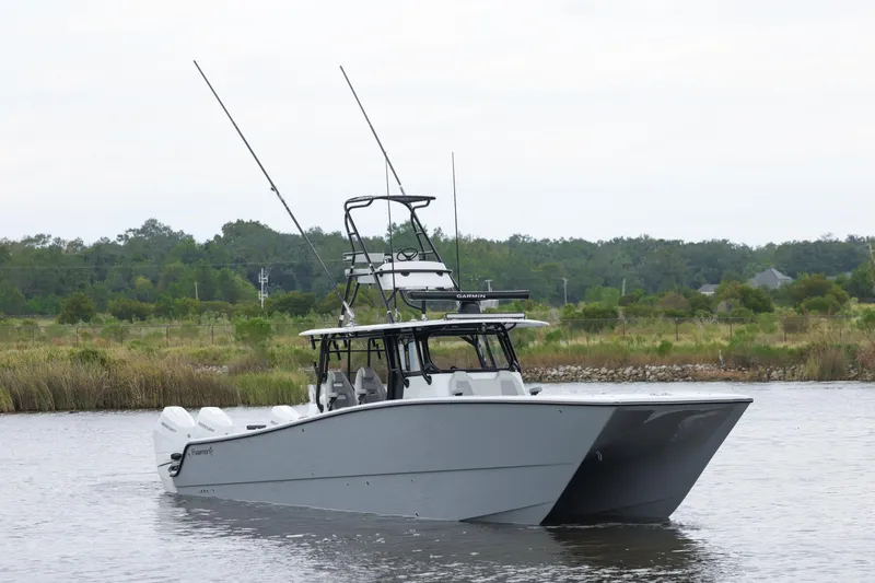 Brand New Yacht Photos Pics 2025 Freeman 42 LR boat on calm water with fishing rods, lush greenery in background.