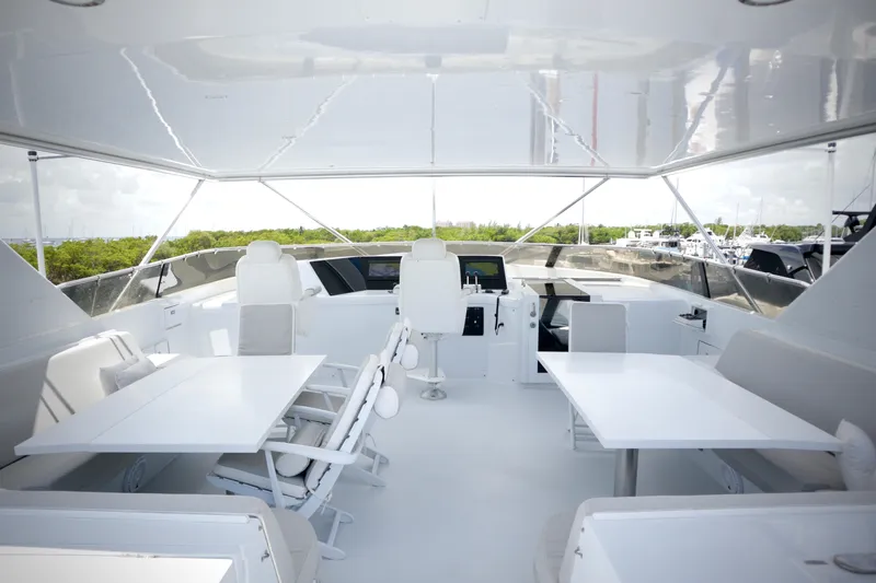 Soul Yacht Photos Pics Luxurious 2002 Hatteras 92 Cockpit Motor Yacht interior with white seating and tables.