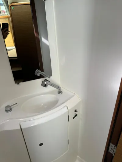 Oscar III Yacht Photos Pics Compact bathroom sink in 2018 Lagoon 380 catamaran, featuring modern fixtures and white cabinetry.