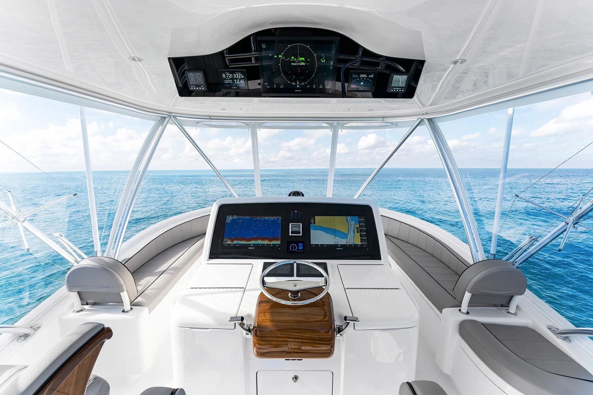 Helm of 2026 Viking 50 Convertible yacht with ocean view and advanced navigation displays.