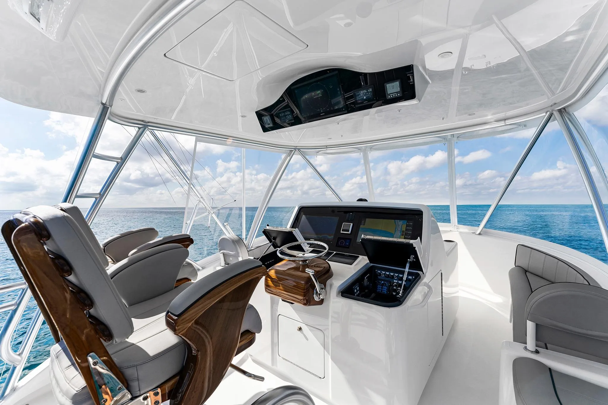 2026 Viking 50 Convertible yacht helm with ocean view, featuring modern navigation equipment.