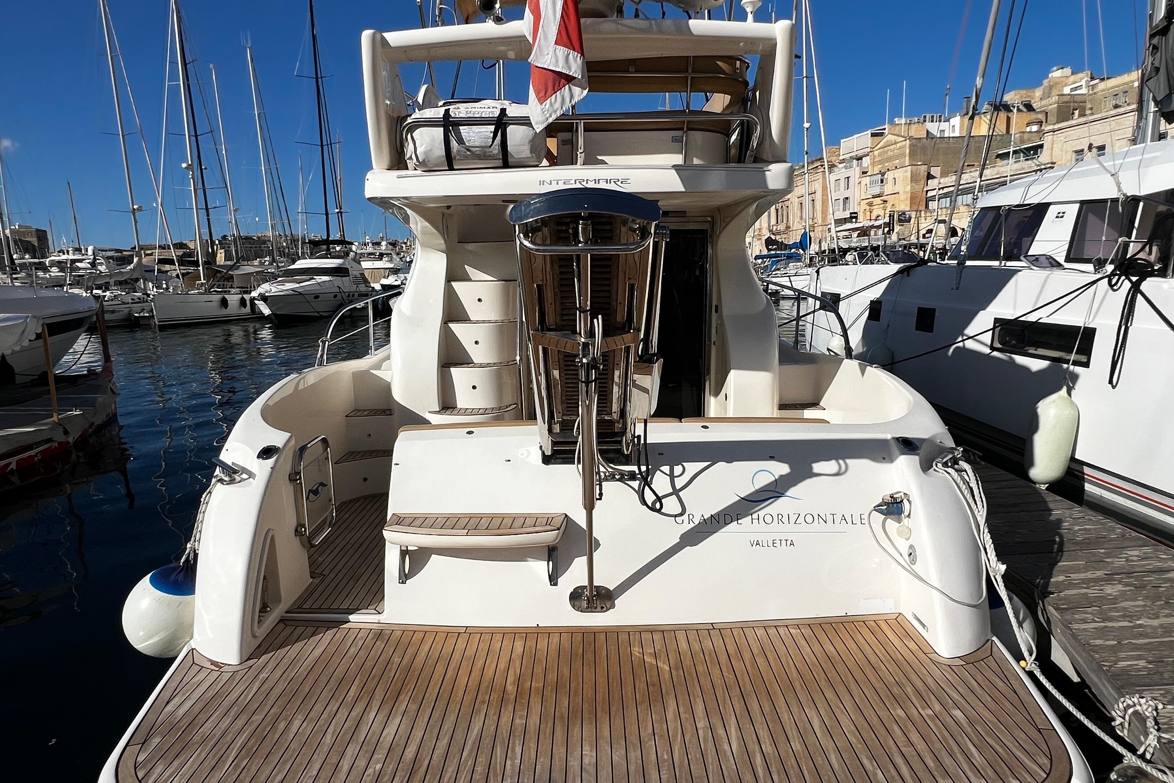 2004 Intermare 37 Fly yacht docked at marina, featuring spacious deck and elegant design.