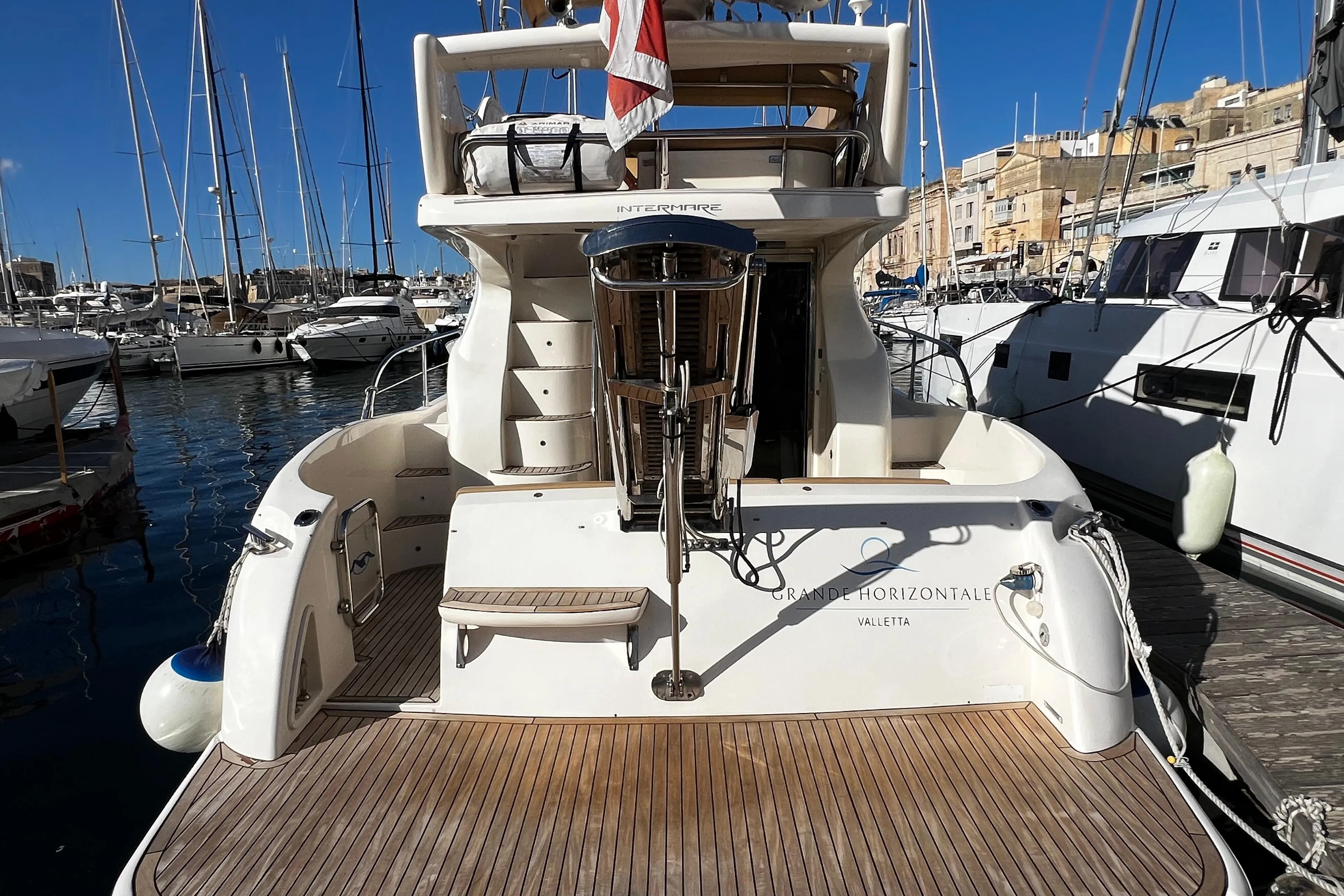 2004 Intermare 37 Fly yacht docked at marina, featuring spacious deck and elegant design.