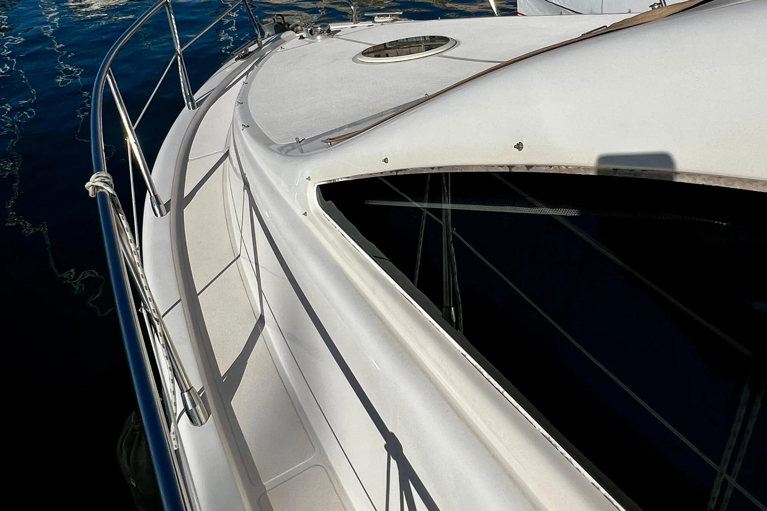 2004 Intermare 37 Fly yacht deck with railing, docked on calm water.