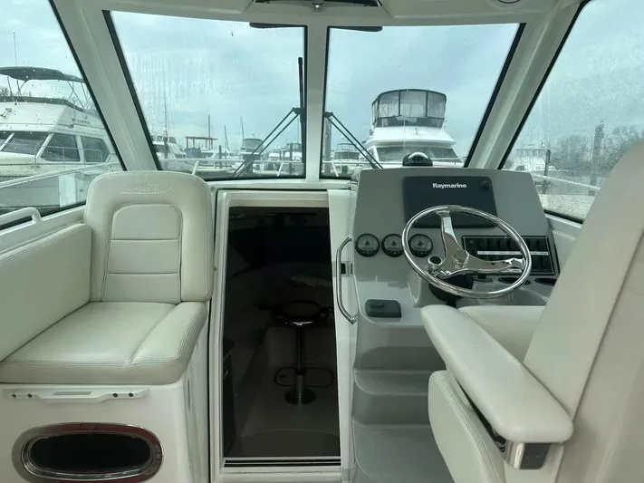  Yacht Photos Pics 2016 Boston Whaler 285 Conquest helm with steering wheel and seating, docked at marina.