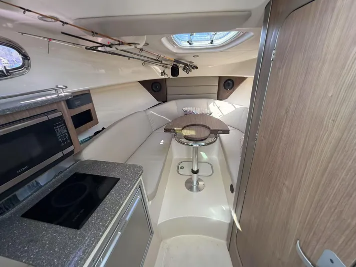  Yacht Photos Pics 2016 Boston Whaler 285 Conquest cabin interior with kitchenette and seating area.