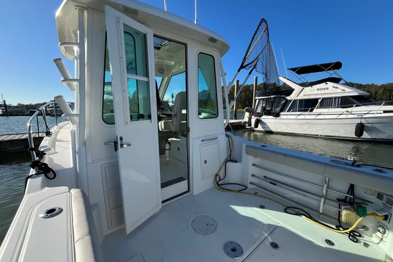  Yacht Photos Pics 2016 Boston Whaler 285 Conquest boat docked, open cabin door, sunny day.
