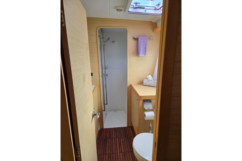 Arias Song Yacht Photos Pics 2016 Lagoon 400 S2 yacht bathroom with shower, toilet, and wooden flooring.