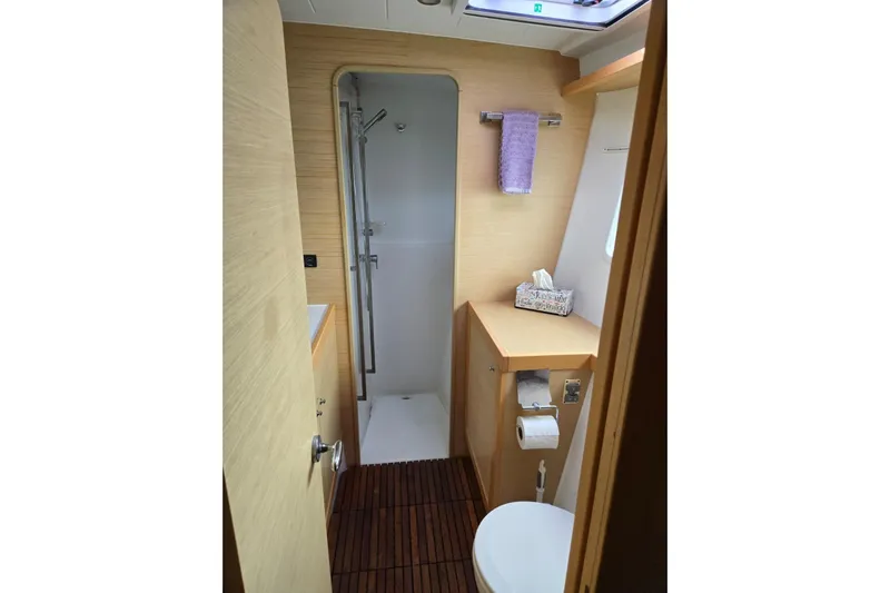 Arias Song Yacht Photos Pics Bathroom interior of 2016 Lagoon 400 S2 yacht with shower and wooden accents.