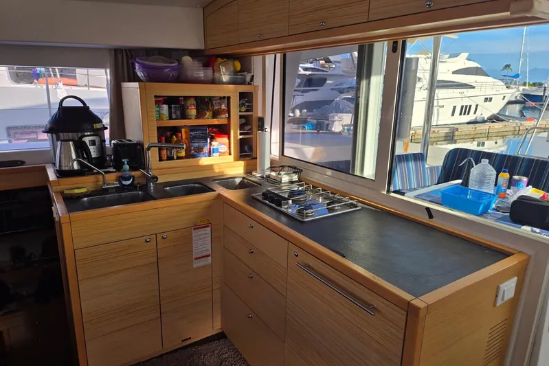 Arias Song Yacht Photos Pics Modern kitchen interior of 2016 Lagoon 400 S2 catamaran with appliances and marina view.