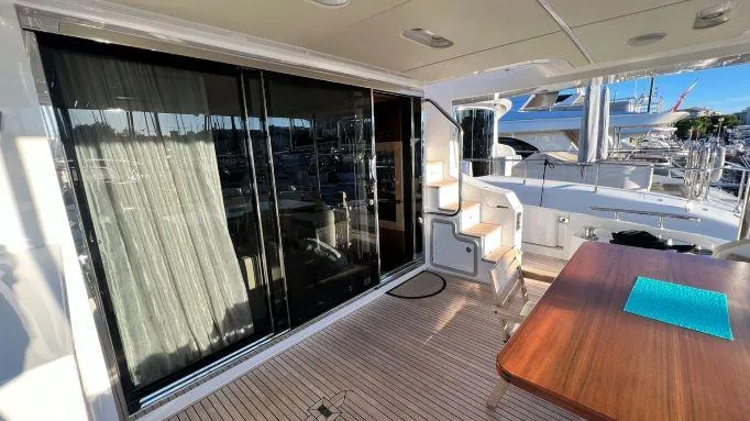  Yacht Photos Pics Luxury Azimut 72 yacht deck with wooden table, sliding glass doors, and marina view.