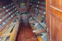 Interior of a vintage 1926 custom motorboat with wooden benches and flooring.