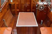 Interior of a 1926 custom motorboat with polished wooden finish and vintage steering wheel.