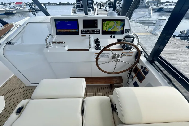  Yacht Photos Pics Helm of 2024 MJM 4 boat with navigation screens and wooden steering wheel.