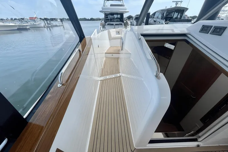  Yacht Photos Pics 2024 MJM 4 yacht deck with sleek design and wooden accents, docked at marina.