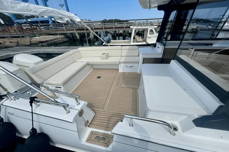  Yacht Photos Pics 2024 MJM 4 boat with spacious deck, comfortable seating, and modern design at a marina.