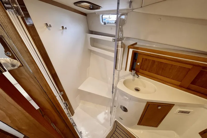  Yacht Photos Pics 2024 MJM 4 yacht bathroom with wooden accents, shower, and sink.